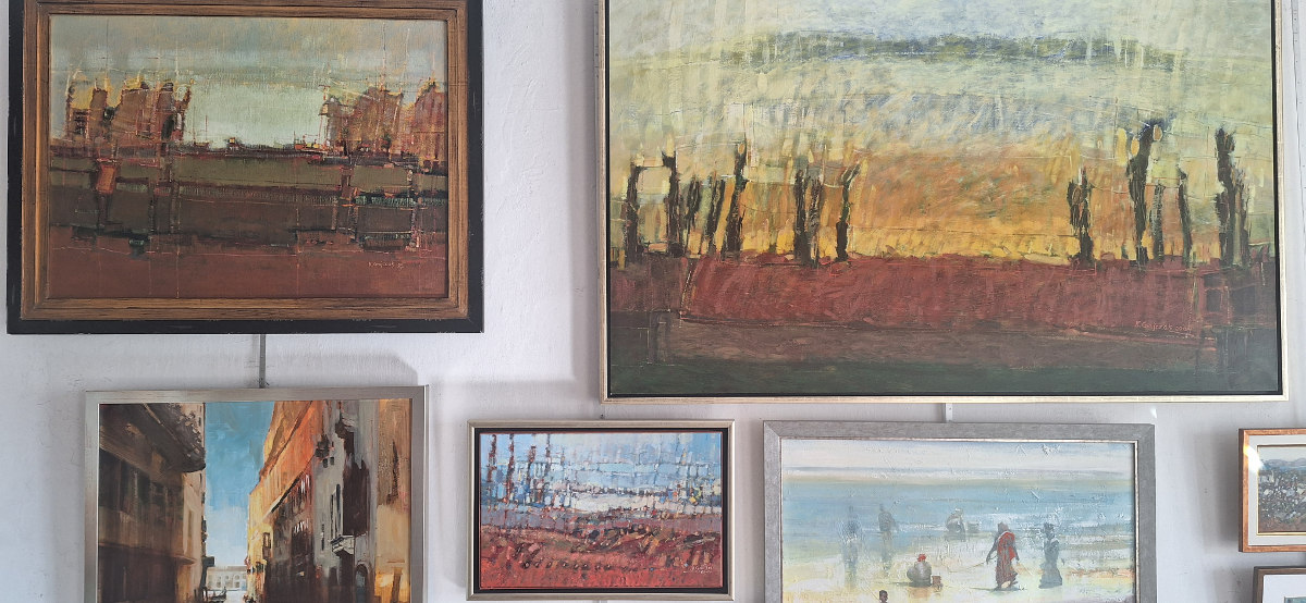 Kilka obrazów wiszących na ścianie galerii